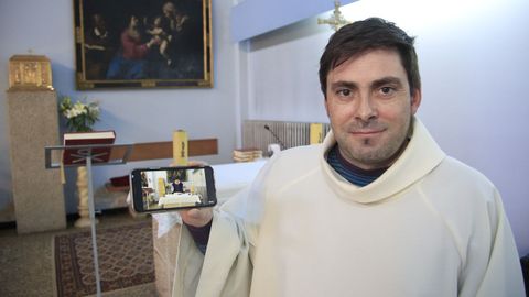 El p�rroco Jos� Luis V�zquez con el m�vil que utiliza para grabar las misas que difunde cada d�a en YouTube