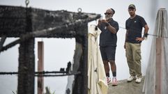 Douglas, el due�o del P� na Praia, a la izquierda, fotografiando los da�os provocados por el incendio en su local.
