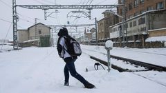 Una persona cruza las vias del tren, en la localidad c�ntabra de Reinosa, cuya comunidad se encuentra en alerta roja por nieve lo que est� complicando el tr�fico en gran parte de la regi�n y en las conexiones con la Meseta y con Vizcaya, por las nevadas pero tambi�n por el granizo que ha hecho su presencia