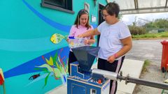 Dos usuarias del centro Misela, manejando una de las m�quinas con las que reciclan pl�stico.