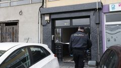 Un agente de polic�a ante el portal del edificio donde ocurri� el crimen machista de Viveiro