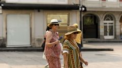 Transentes ataviadas con gorros, ropa veraniega y gafas de sol para protegerse del calor en Lugo.