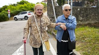 Caminando cerca de su casa acompa�ada por una voluntaria que la ayuda