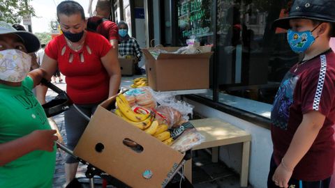 Una mujer recoge alimentos distribuidos por el Centro Internacional de Avivamiento en Chelsea, Estados Unidos