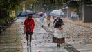 Dos mujeres pasen bajo la lluvia en el paseo de Los �lamos, en el centro de Oviedo