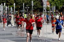 Corredores de un maratón del estudiante se refrescan en la fuente de la Compañía.