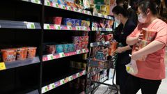 Clientes de un supermercado en Pek�n hacen compras de �ltima hora para adelantarse a un posible confinamiento.