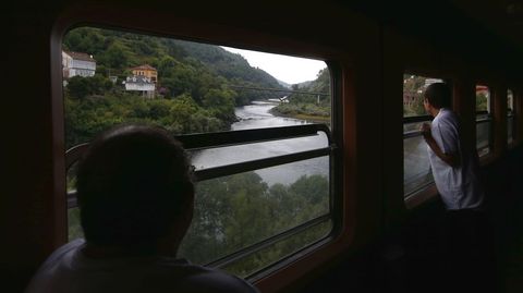 Dos viajeros observan el pasaje de la Ribeira Sacra desde el vag�n cafeter�a del Galaico Expreso