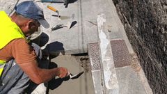 Un operario trabajando en la reparaci&oacute;n de una acera en Cambados