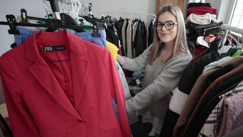 Andrea Rivas posa entre las prendas de segunda mano que tiene a la venta. 