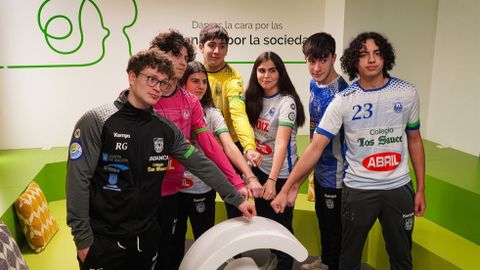 Miembros del Cisne Balonmano de Pontevedra con los brazaletes de la AECC