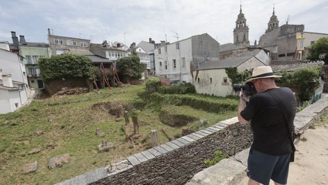 Un turista fotografiando este 24 de junio el Pazo de Dona Urraca y el �rea donde se va a intervenir, junto a la Muralla de Lugo