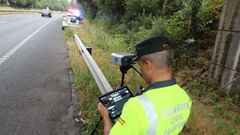 Un guardia civil examina los datos del lector de matr�culas que detecta coches sin ITV y sin seguro.