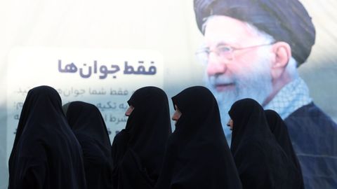 Mujeres con velo caminan frente a un retrato del ayatol� Ali Jamenei, en Teher�n.