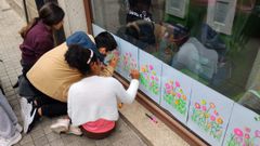Alumnas decorando un dos escaparates dos comercios de Celanova.