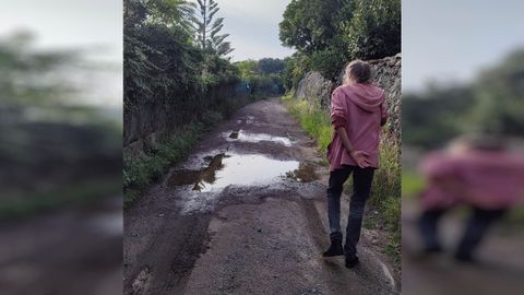 Anna sortea los charcos en el camino pblico de acceso a su casa, en Ancoradoiro.