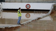 Un paso inferior inundado en Aldaya (Valencia), supervisado por un operario.