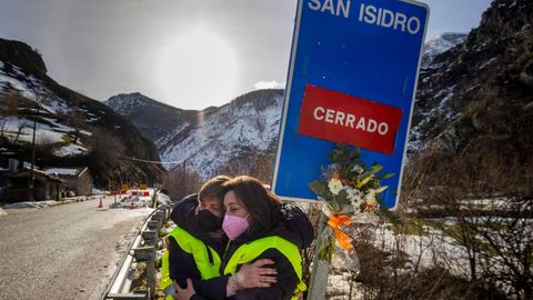 Dos mujeres rinden homenaje a los trabajadores sepultados en San Isidro colocando un ramo de flores