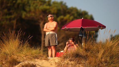 Una hombre mira al eclipse en la playa de Doni�os.