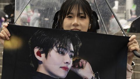 Una fan posa con un poster de�uno de los miembros del grupo�BTS