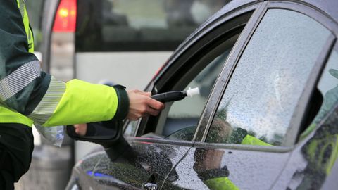 Un guardia civil realiza la prueba de alcoholemia a un conductor en una carretera de Lugo.