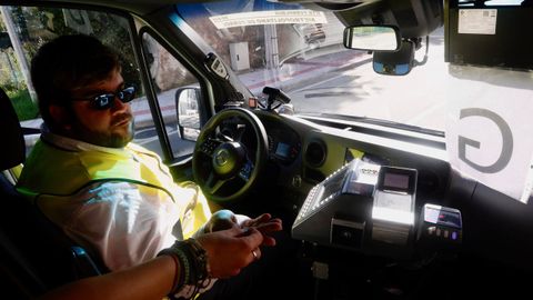 Cristian Vilasuso, conductor del autob�s G de Ferrol, la nueva l�nea circular, cobra a un usuario en la parada de San Xo�n.