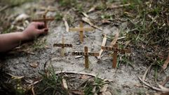 Un activista establece cruces con el nombre de varias mujeres asesinadas en El Salvador.