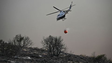 Un helic�ptero de extinci�n de incendios arroja agua sobre el incendio forestal.