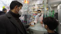 Un padre recoge uno de los test de ant�genos para ni�os en una farmacia ourensana