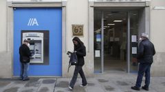 Clientes de un banco con mascarillas, este lunes en el centro de Monforte