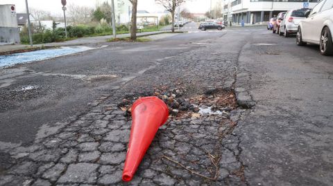 Gran bache en la calle P�rez Parall�, en Canido, con un cono de se�alizaci�n que aparece tirado con asiduidad.