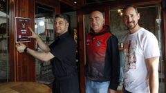Jos� Ram�n Mu�iz y Luis Pi�eiro, entregando uno de los carteles en el restaurante Arume.