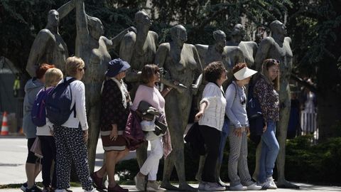 Un grupo de turistas se fotograf�a con el Monumento a la Concordia de Oviedo