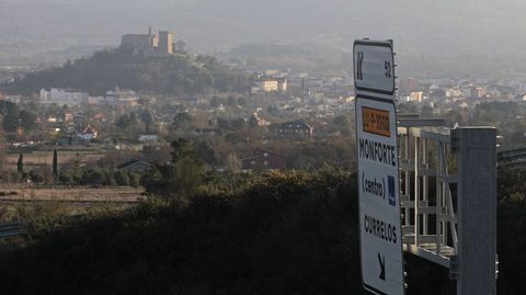 Indicador del acceso al hospital de Monforte desde el corredor de Lugo, con el casco urbano al fondo