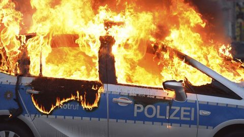 Coche de la polica ardiendo.