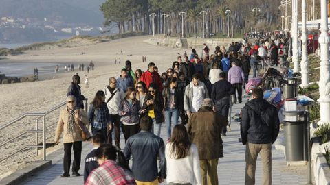 Paseantes en la playa de Samil.