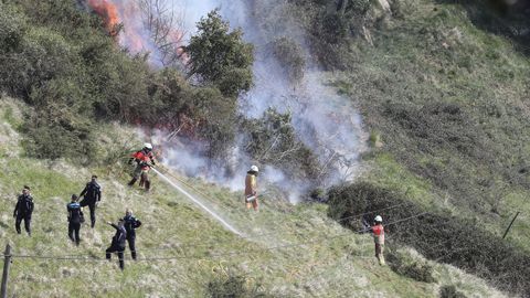 Unos bomberos trabajan este viernes en las tareas de extinci�n del incendio que comenz� esta madruga en las laderas del monte Naranco, en las cercan�as del casco urbano de Oviedo