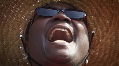 Una mujer canta un himno durante el servicio religioso improvisado.