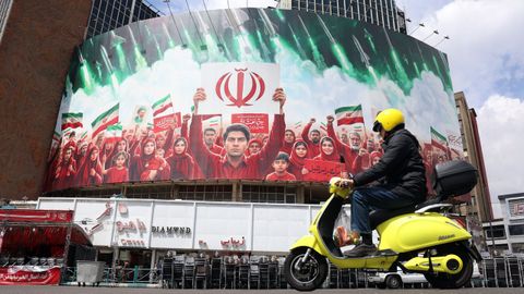 Valla con j�venes portando banderas iran�es en la plaza Valiasr de Teher�n.