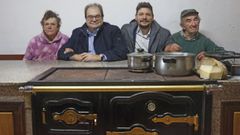Fernando Nez, en la cocina de la casa de su prima Angelitia (a la izquierda) en Riob, junto a su hijo y Manolo, otro familiar. 