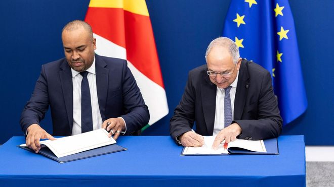 El ministro de Pesca de las islas Seychelles,Wallace Cosgrow, firma al lado del comisario (derecha) en el nuevo protocolo