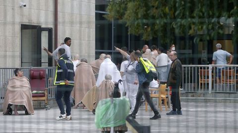 Unos polic�as reciben indicaciones del personal de la residencia para entrar en el edificio mientras los bomberos apagaban el fuego