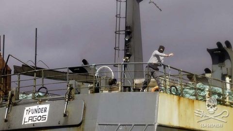 Un oficial del Thunder arroja un objeto a la lancha de los ecologistas que persiguen al barco. 