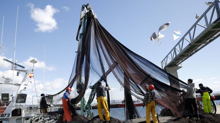 Tripulantes de un pesquero trabajando con las redes en el puerto de Ribeira en marzo del 2025.