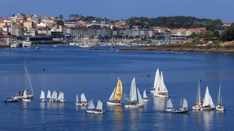 Embarcaciones de la escuela de vela del Real Club N�utico de Sanxenxo frente al puerto deportivo y la playa de Silgar