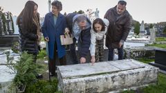 Juana Bouzas (con abrigo azul) junto a otros vecinos de De�n ante la tumba de Carmen.