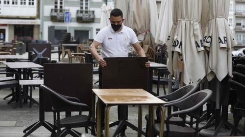 Los camareros preparan las mesas en un bar de Santiago