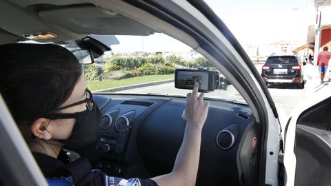 Una polic�a, este domingo, muestra c�mo funciona la aplicaci�n que usan en los controles para saber la procedencia de los veh�culos en el puente