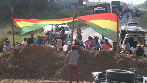 Seguidores de Evo Morales, junto a una barrera de tierra en medio de una carretera de Santa Cruz (Bolivia)