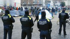 Agentes de la Polic�a Local de Badalona (Barcelona) controlan a los inmigrantes desalojados del antiguo instituto B9.